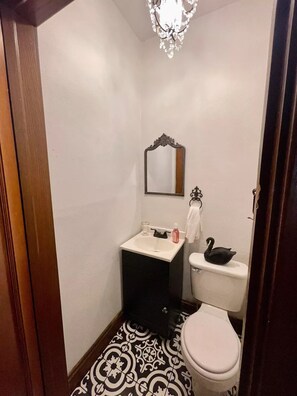 A small bathroom with a white sink, a mirror, a toilet, and a decorative swan. - 629 on Main Rental A
(Point Pleasant)