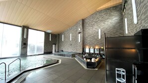 Un área de spa con piscina, asientos y sauna.