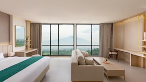 Habitación de hotel con una cama grande, un sofá, un escritorio y vistas a la montaña.