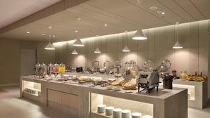 Una mesa de buffet con diferentes alimentos y una máquina de café.