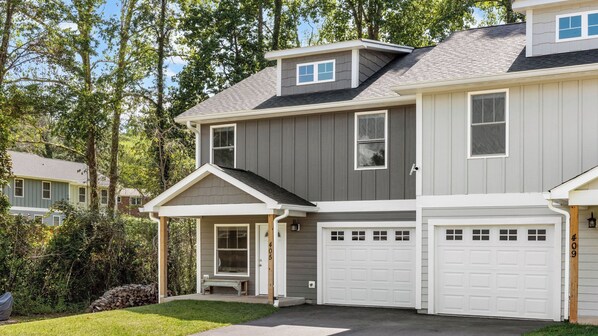 A two-story house with a garage, a covered porch, and a small front yard. - Little Sycamore by Avantstay Premier Location + Patio (Asheville)