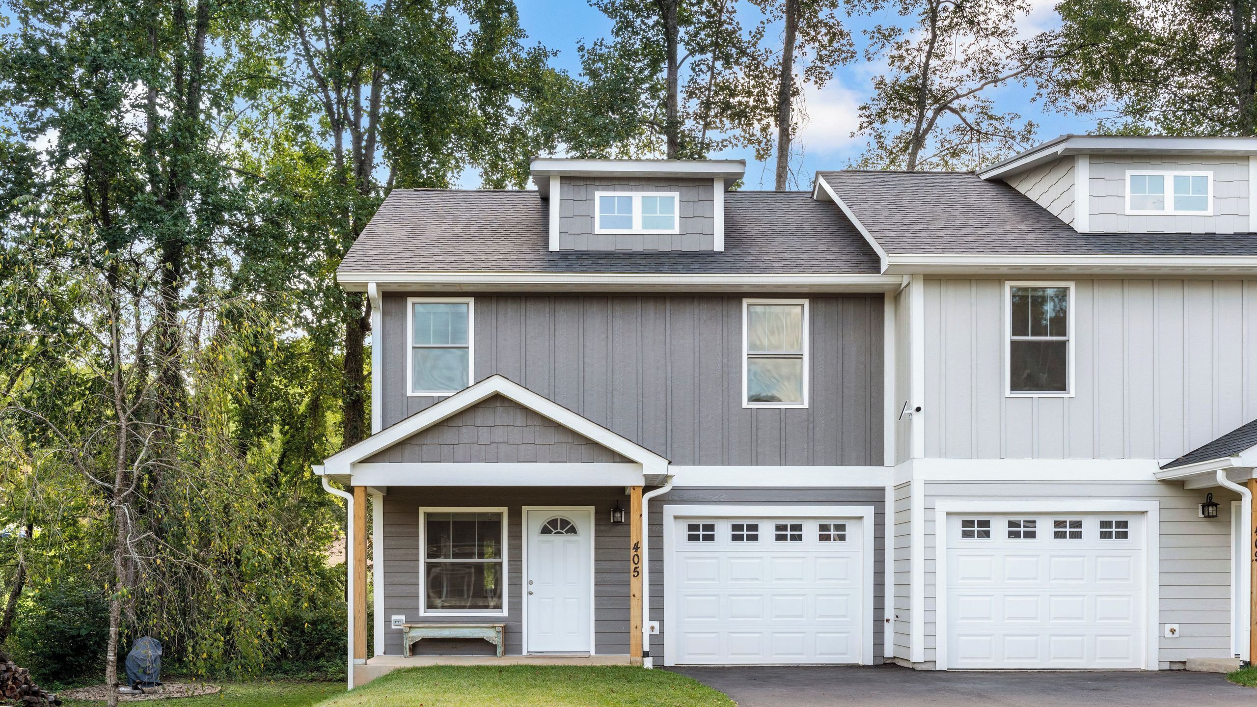 A two-story house with a front porch, a garage, and a small attached garage.