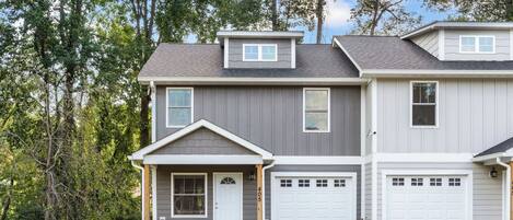 A two-story house with a front porch, a garage, and a small attached garage.