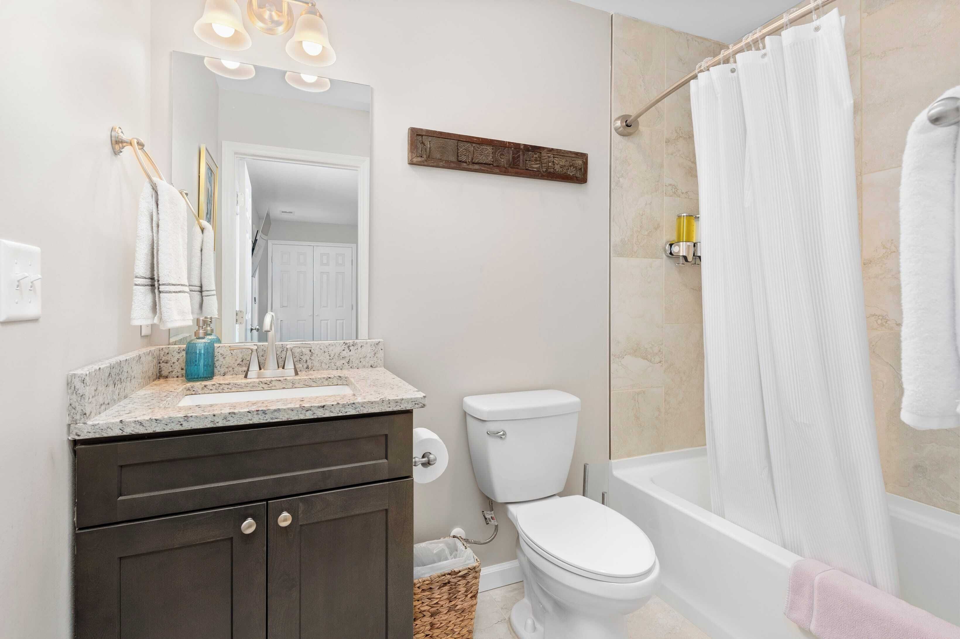 A bathroom with a sink, toilet, and bathtub.