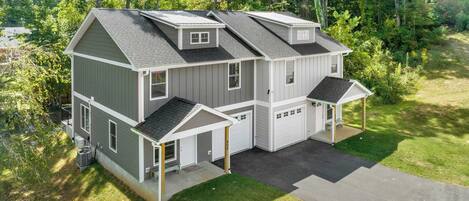 A two-story house with a garage, a covered porch, and a small attached shed.