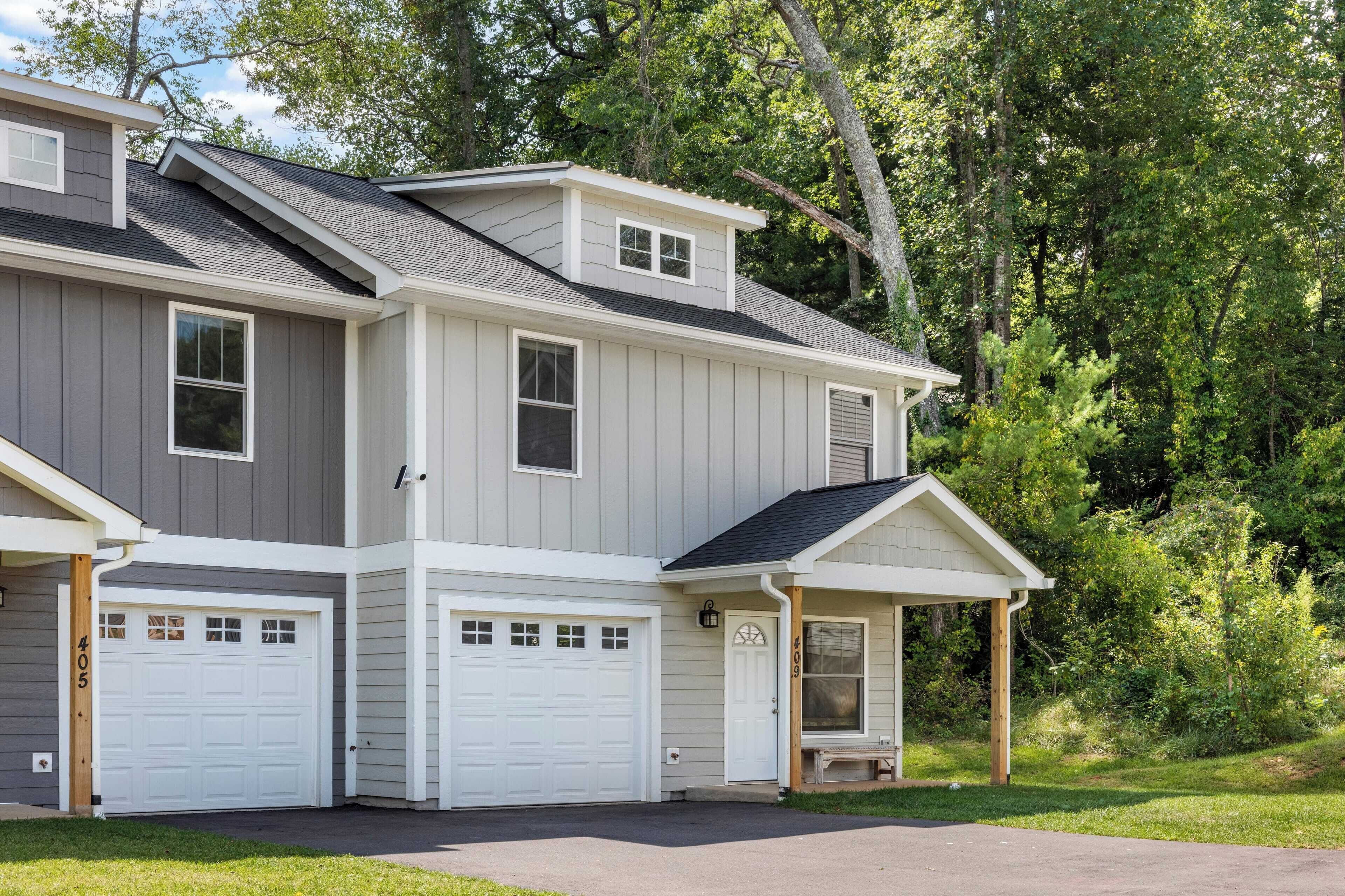 A two-story house with a garage, a covered porch, and a small deck.