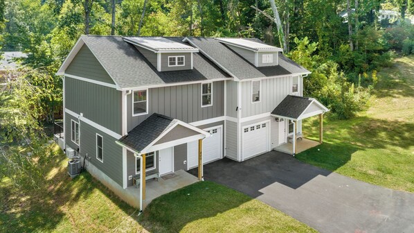 A two-story house with a garage, a covered porch, and a driveway.