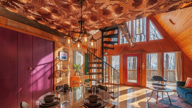 A spacious dining area with a high ceiling, a spiral staircase, and large windows. - Firepit + Mountain Views A-frame in Fairview Honeycomb Hideaway by Avantstay (Fairview)