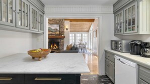 A kitchen with a marble countertop, a dishwasher, and a stone fireplace. - Hamersmith Hollow Retreat by Avantstay Mountain Views (Mars Hill)