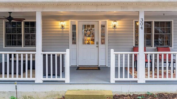 A house with a front porch, a door with a wreath, and a number '304' on the wall. - Asheville Cottage Retreat by Avantstay A+ Charm (Fairview)
