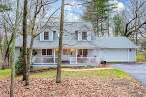 A two-story house with a porch, surrounded by trees. - Asheville Cottage Retreat by Avantstay A+ Charm (Fairview)