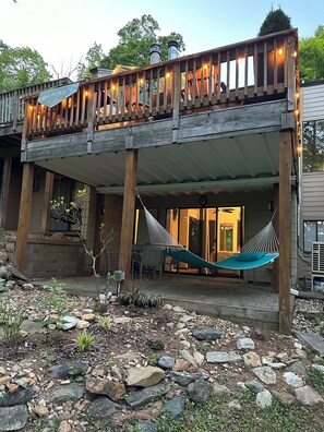 A wooden deck with a hammock, a covered patio area, and a stone pathway leading to the entrance. - Woolly Bull-Cozy Newly Redecorated 2-Story Townhouse. <0.3 Mile Walk to slopes! (Wintergreen Resort)