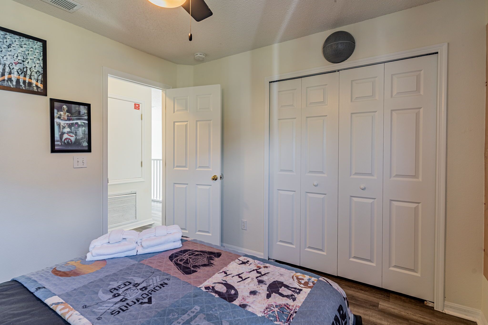A bedroom with a bed, a door, and a closet.