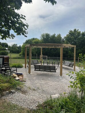 A gazebo with benches, surrounded by gravel and greenery. - Spacious 27’ RV on horse farm (Bristol)