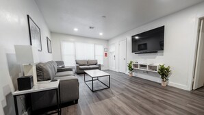 Un salon moderne avec un canapé, une table basse et un téléviseur.