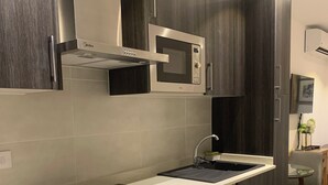 Une cuisine moderne équipée d’un four à micro-ondes, d’un four et d’une plaque de cuisson intégrés.