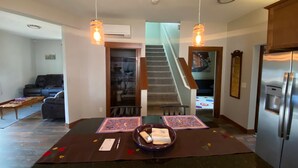 A dining area with a table set for two, a refrigerator, and a staircase leading to another floor. - Cozy Cole St Home built in 1910 in Downtown Enumclaw (Enumclaw)