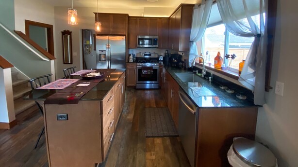 A modern kitchen with wooden cabinets, stainless steel appliances, and a central island. - Cozy Cole St Home built in 1910 in Downtown Enumclaw (Enumclaw)