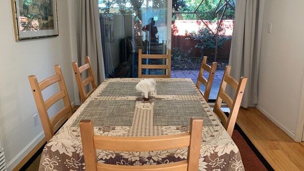 Een eethoek met een tafel voor zes personen, omringd door houten stoelen.