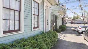 A row of light blue houses with white trim, numbered 1758, along a sidewalk with a parked car and a stop sign in the background. - Cute centrally located 1bed 1bath walk to French Q, Bourbon St & Jazz venues  (New Orleans)