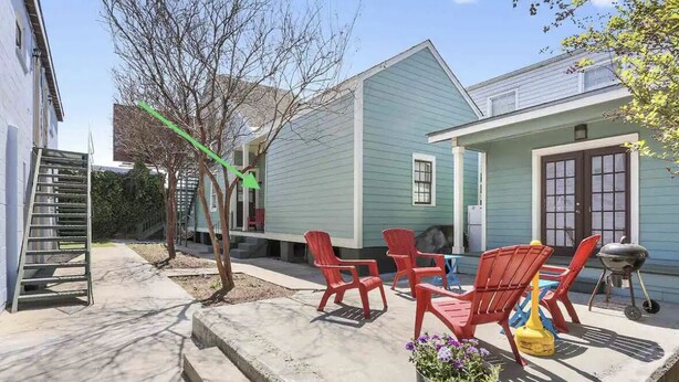 A house with a blue exterior, a front porch with red chairs, a barbecue grill, and a green tree. - Cute centrally located 1bed 1bath walk to French Q, Bourbon St & Jazz venues  (New Orleans)