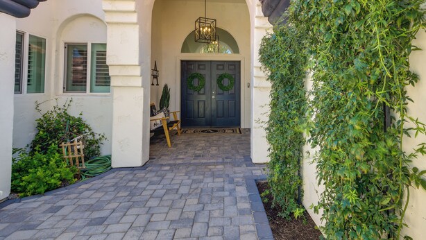 A house entrance with a brick pathway, a dark blue door with wreaths, and a hanging light fixture. - 1 Mi to Water Ranch! Family Retreat w/ Resort Pool (Gilbert)