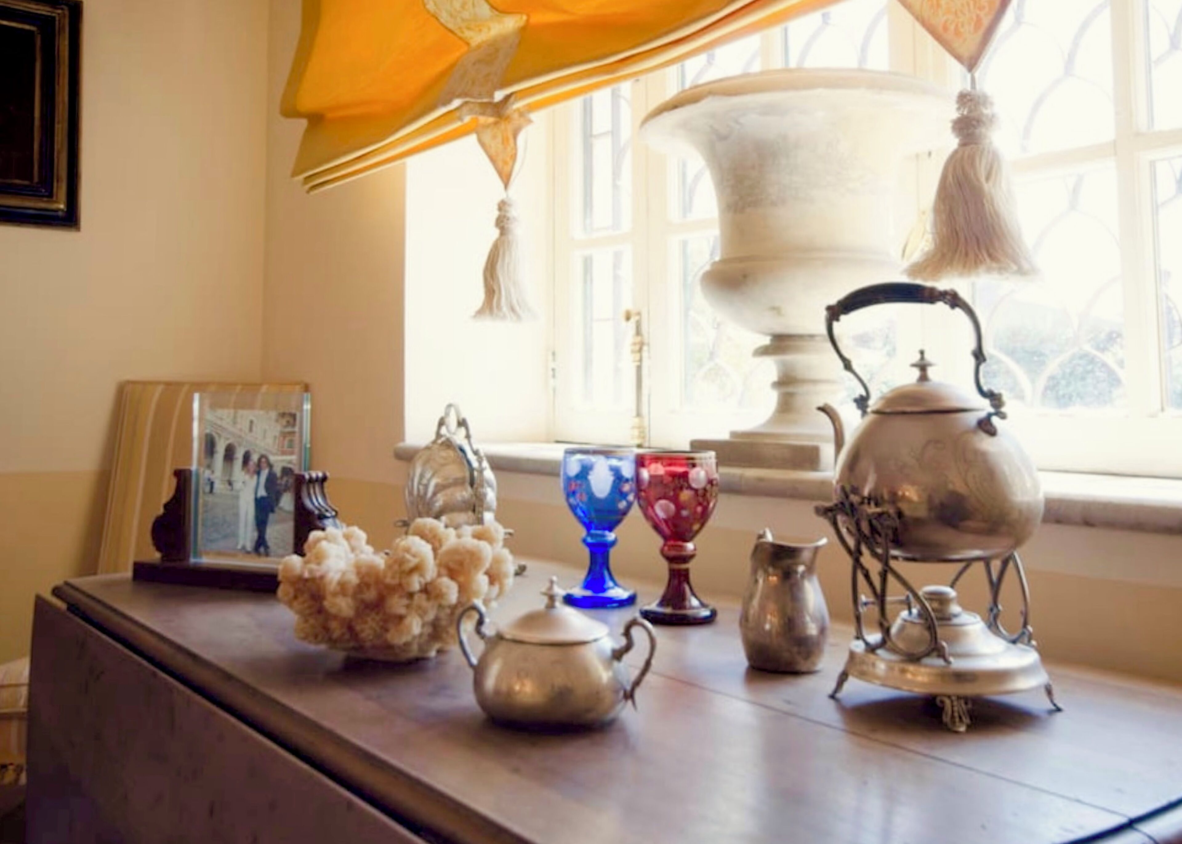 A table with various decorative items including a teapot, a vase, and a framed photo.