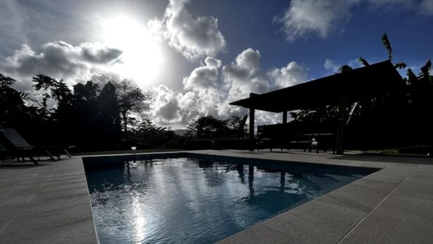 En swimmingpool med fri sikt upp mot himlen och molnen.