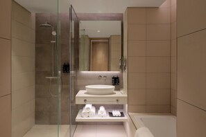 A modern bathroom with a glass-enclosed shower, a large sink, and a vanity with towels and toiletries. - Holiday Inn Dubai Business Bay by IHG (Dubai)