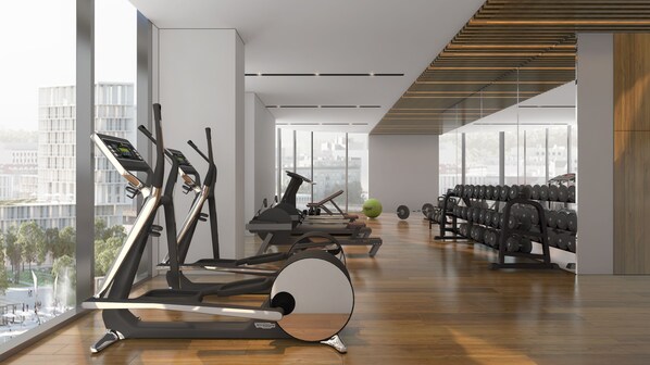 A modern gym with treadmills, a rowing machine, and a rack of dumbbells.
