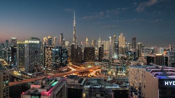 Eine Skyline mit hohen Gebäuden, darunter ein markanter Turm, und eine belebte Straße mit Lichtern.