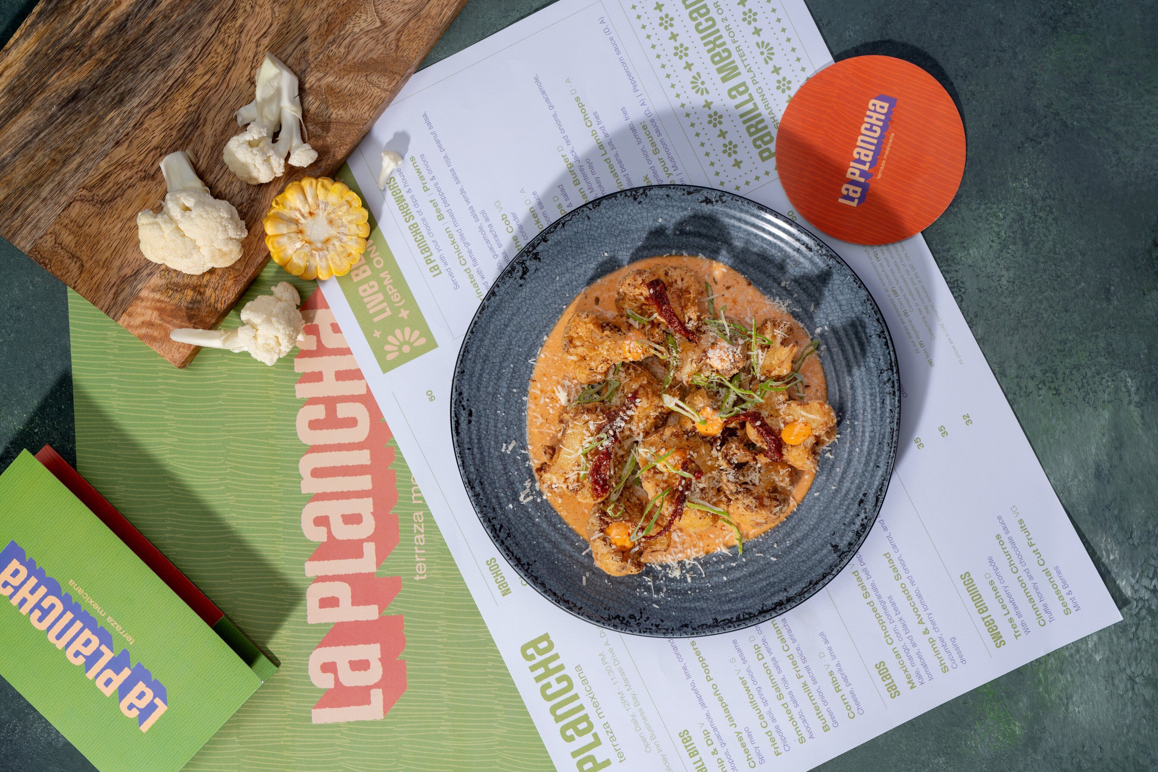 A plate of food on a menu with a wooden cutting board and some vegetables.