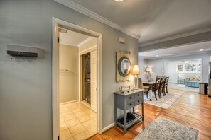 A hallway with a laundry room, a console table with a mirror, and a dining area with chairs and a table. - Lake Anna Deep Water Cove + Covered Dock + 4BR + Hot Tub + Firepit +Dog Friendly (Mineral)