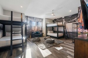 A modern room with bunk beds, a sofa, and a mural of Times Square. - Chateau at Bear's Den: Pool, Arcade Games, Golf Views, Free Water Park (Kissimmee)
