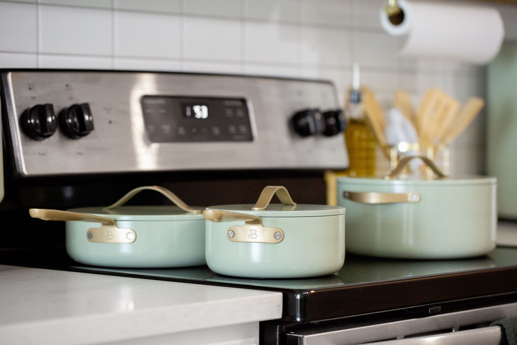 Une cuisine équipée d’un four en acier inoxydable et de trois casseroles bleu clair sur la cuisinière.