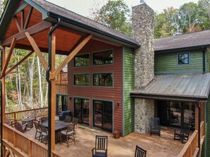 A multi-story house with a deck, outdoor seating, and a stone chimney. - Beagle's Rest at Eagles Nest - dogs ok, hot tub (Banner Elk)
