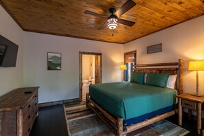A wooden ceiling fan, a bed with a green bedspread, a wooden nightstand with a lamp, and a wooden dresser. - Beagle's Rest at Eagles Nest - dogs ok, hot tub (Banner Elk)