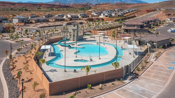 Zona residencial con piscina, casas y montañas al fondo.