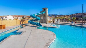 Una piscina con tobogán y una torre de socorristas.