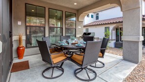 An outdoor patio with a round table, four chairs, and a grill. - Sienna Hills Retreat | Connected homes with 10 Bedrooms, sleeps 40, and endless amenities! (Utah)