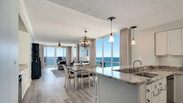 Une cuisine spacieuse avec un grand îlot central, un coin repas offrant une vue agréable et un balcon avec vue.