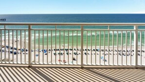 Un balcon avec vue sur la plage et l’océan.