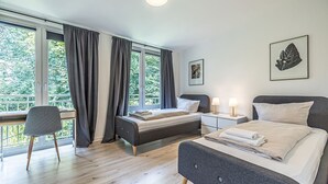 Ein modernes Schlafzimmer mit zwei Betten, einem Schreibtisch und einem Stuhl.