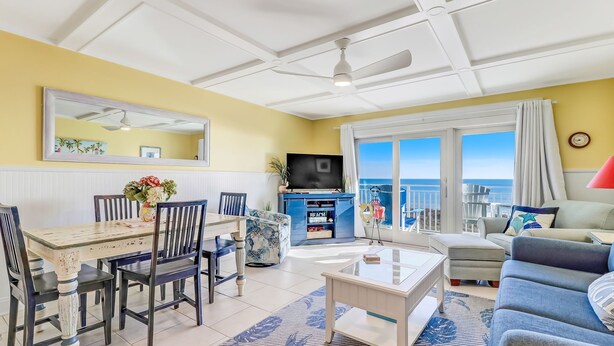 A living room with a dining area, a TV, and a view of the ocean. - Beachfront Oasis on Amelia Island Condo - 2 Bedroom Ketch Courtyard (Fernandina Beach)