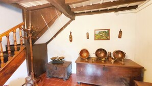 A wooden staircase with a rustic design, a small chest of drawers, and a painting on the wall.