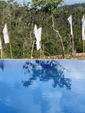 A clear blue pool with reflections of trees and flags in the background. - Fight Club Philippines (Puerto Princesa)
