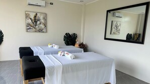 A spa room with two massage tables, a large mirror, and artwork on the walls. - Fight Club Philippines (Puerto Princesa)
