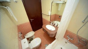 A bathroom with a toilet, sink, and bathtub. - Two Bedroom Apartment Near Al Khan Beach By E R (الشارقة)