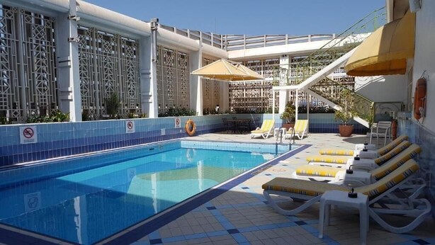 Et tagomr åde med swimmingpool, liggestole og parasoller.