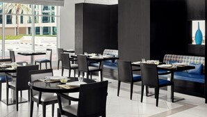 A modern restaurant with black and blue seating, large windows, and a view of the outside. - Standard Room Near Safa Park with Free Breakfast (دبي)